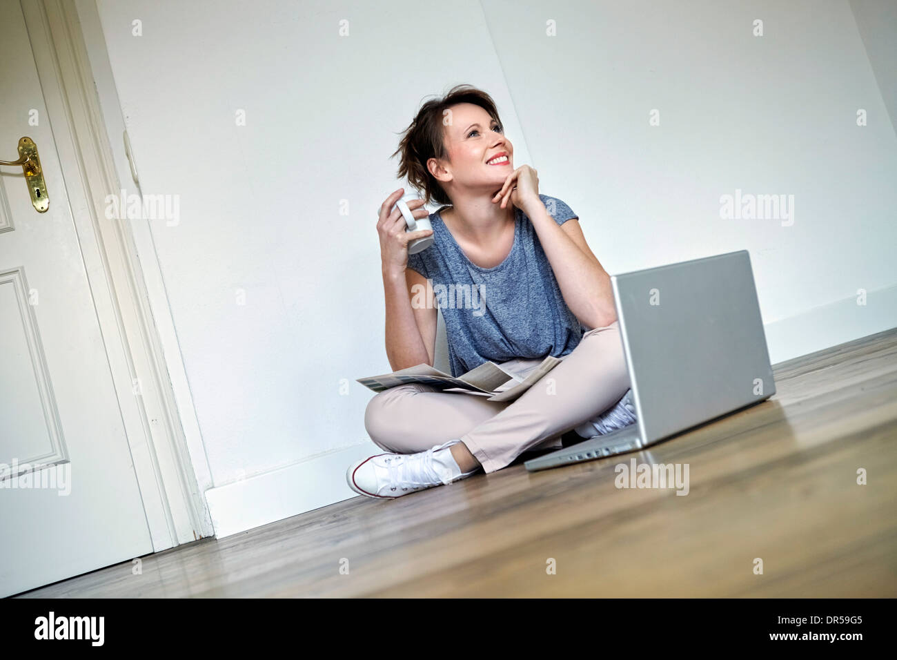 Giovane donna prende una pausa caffè, laptop in primo piano, Monaco di Baviera, Germania Foto Stock