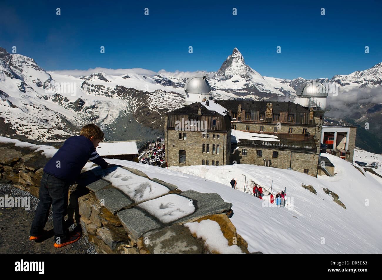 Ragazzo che guarda verso il basso con lo sfondo del Cervino (Monte Cervino), Svizzera Foto Stock