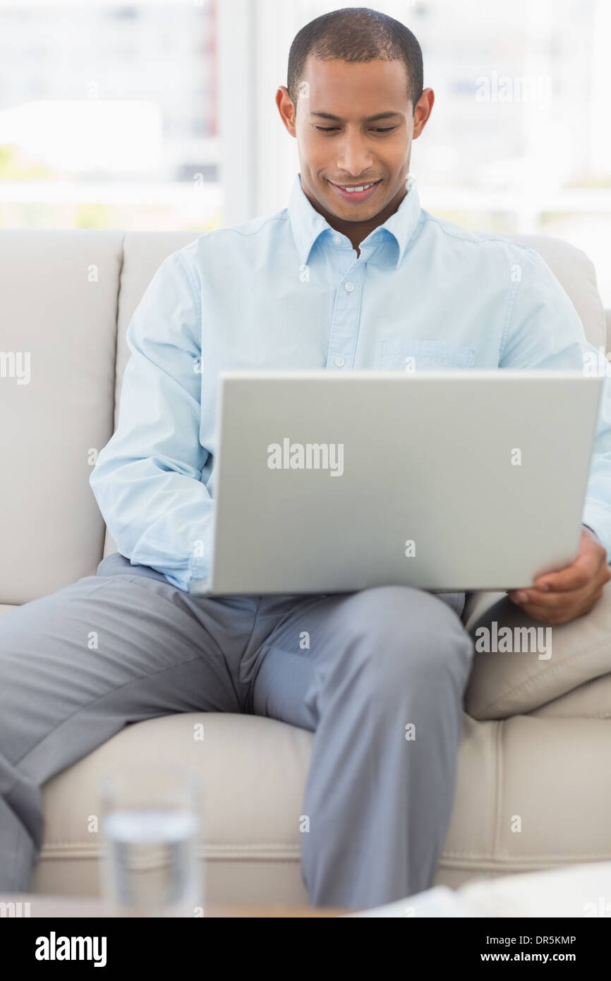 Happy businessman lavorando sul computer portatile sul divano Foto Stock