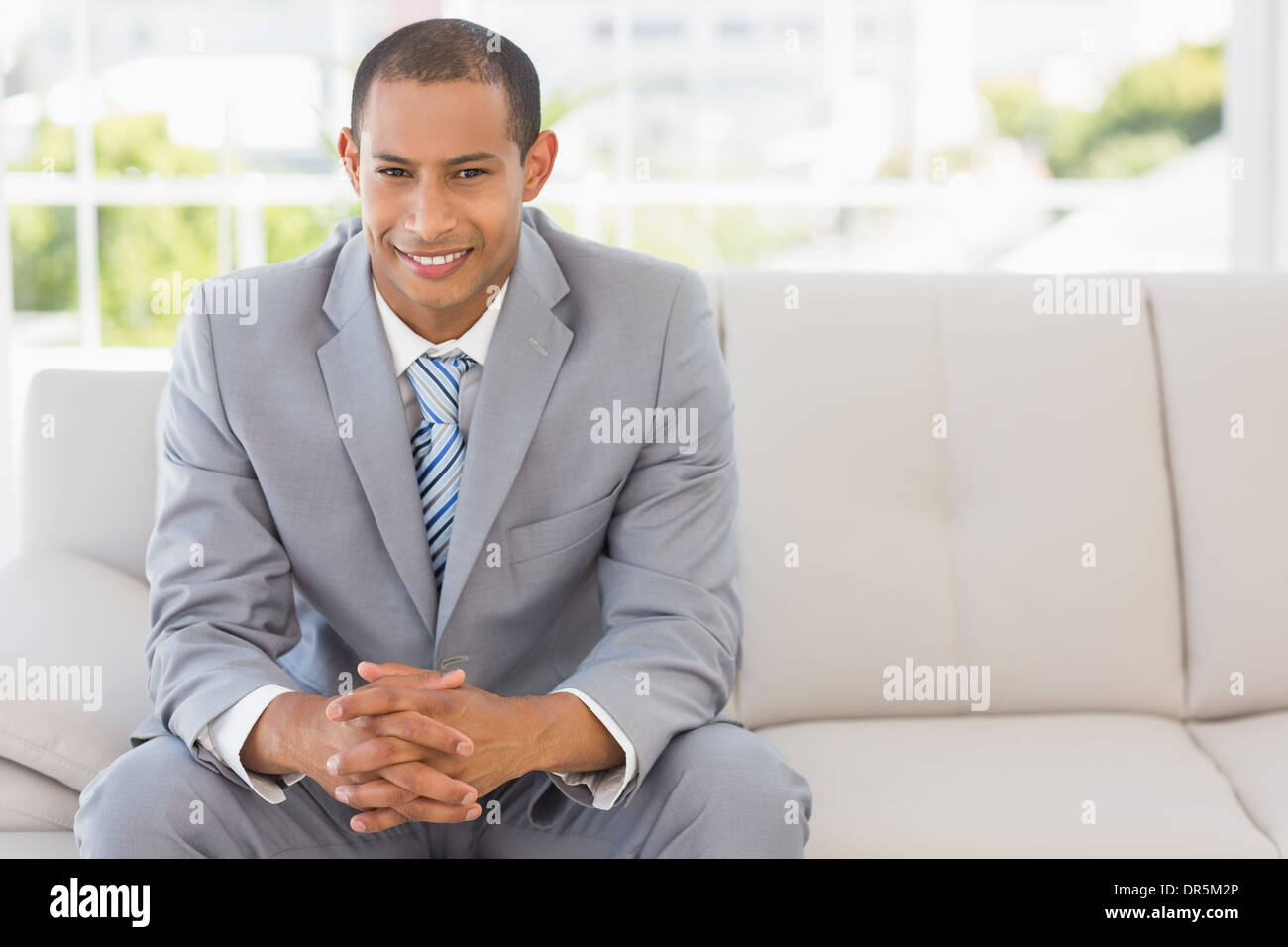 Imprenditore sorridente seduto sul lettino Foto Stock