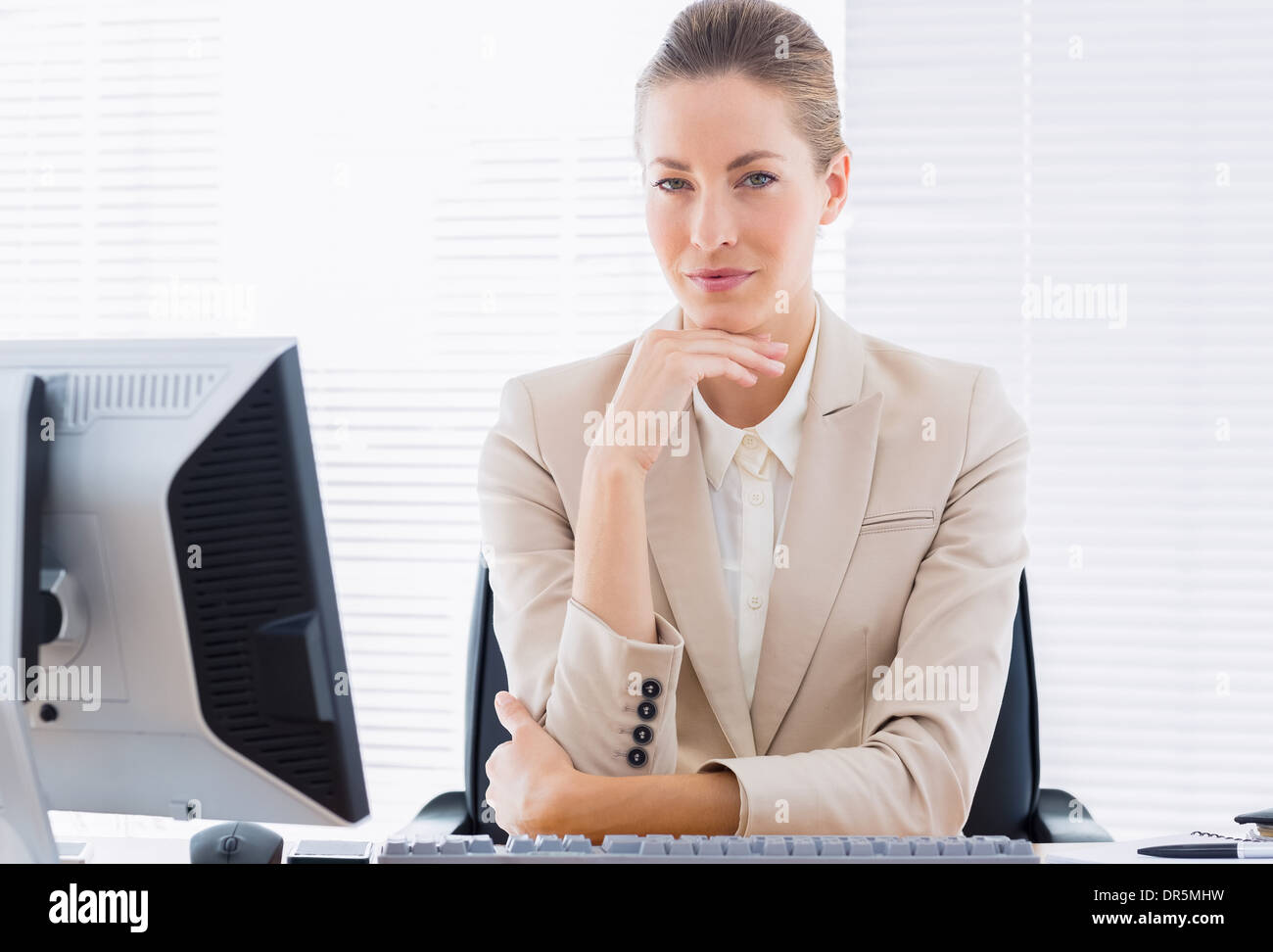 Imprenditrice grave con il computer alla scrivania in ufficio Foto Stock
