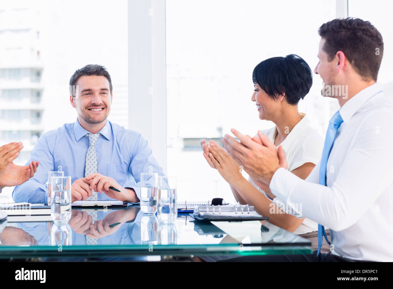 I dirigenti battendo intorno a un tavolo per conferenza Foto Stock