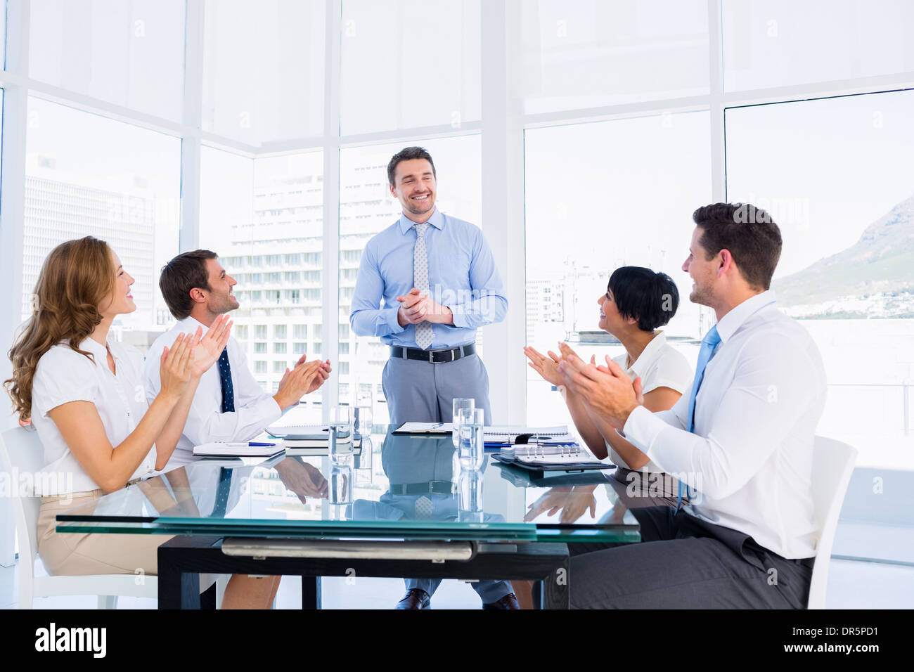 I dirigenti battendo intorno a un tavolo per conferenza Foto Stock