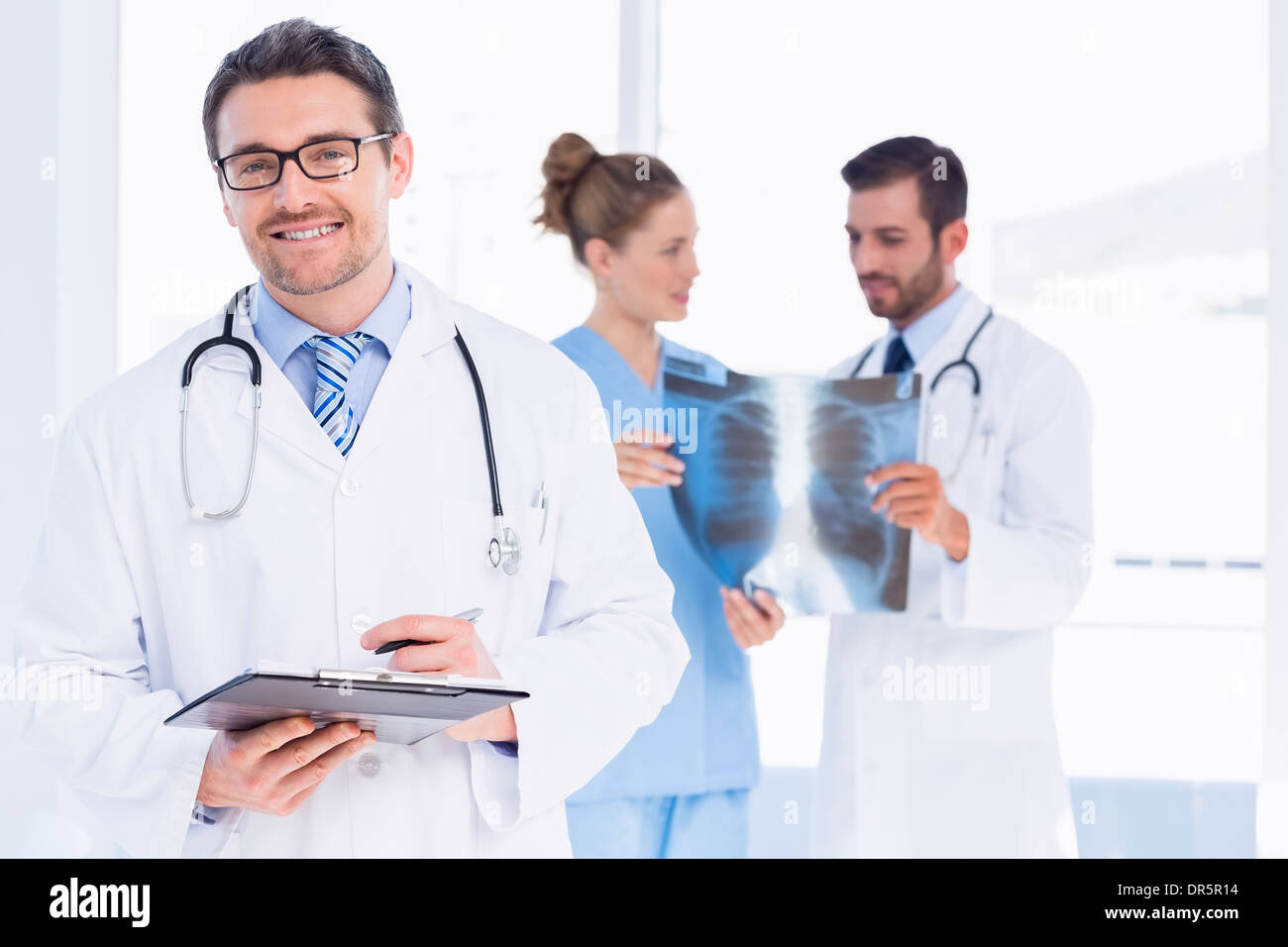 Medico tenendo i rapporti con i colleghi di esaminare x-ray Foto Stock