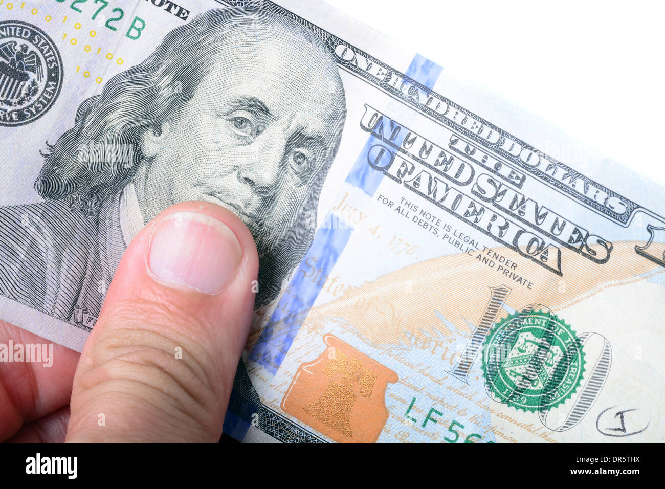 L'uomo dita tenendo una nuova denominazione di un centinaio di dollari Foto Stock
