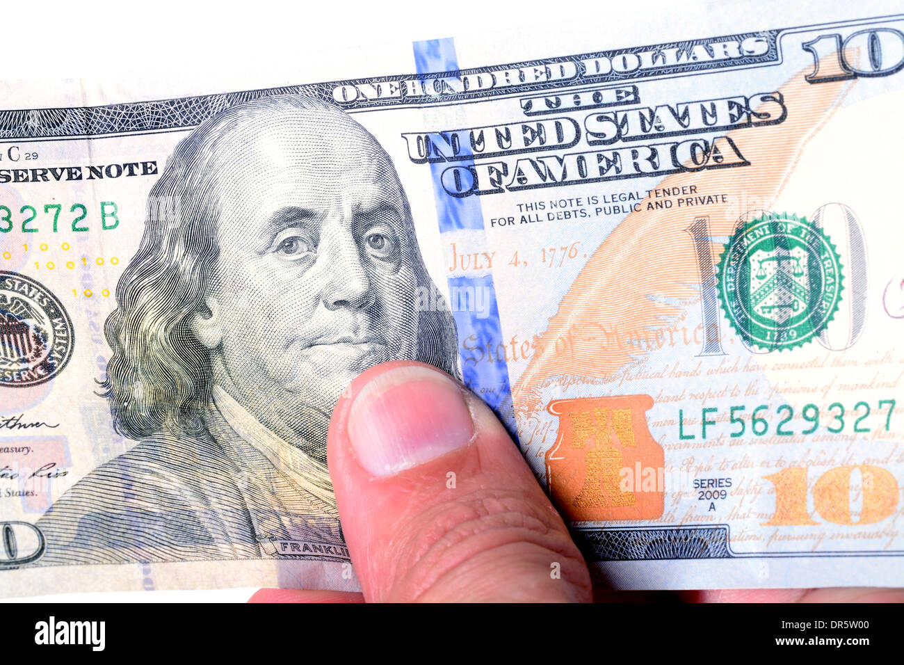 Macro di una mano che afferra un nuovo di zecca di un centinaio di dollari Foto Stock