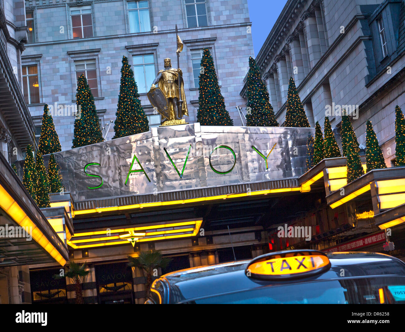 SAVOY HOTEL & TAXI Vista esterna del lussuoso ingresso del Savoy Hotel a cinque stelle a Natale con Londra taxi a noleggio in primo piano The Strand London Foto Stock