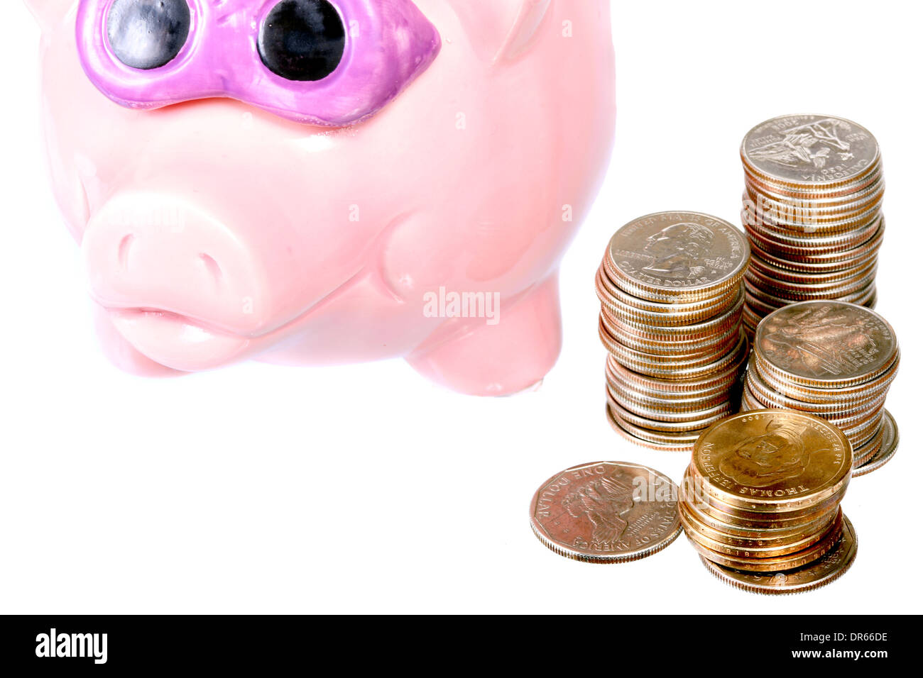Moderno salvadanaio e pile di monete isolato su bianco Foto Stock