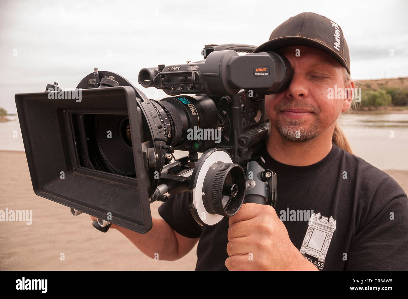 Cameraman consente di girare video in HD con un primo obiettivo in un polveroso e poveri città in Sud Africa settentrionale di Cape. Foto Stock