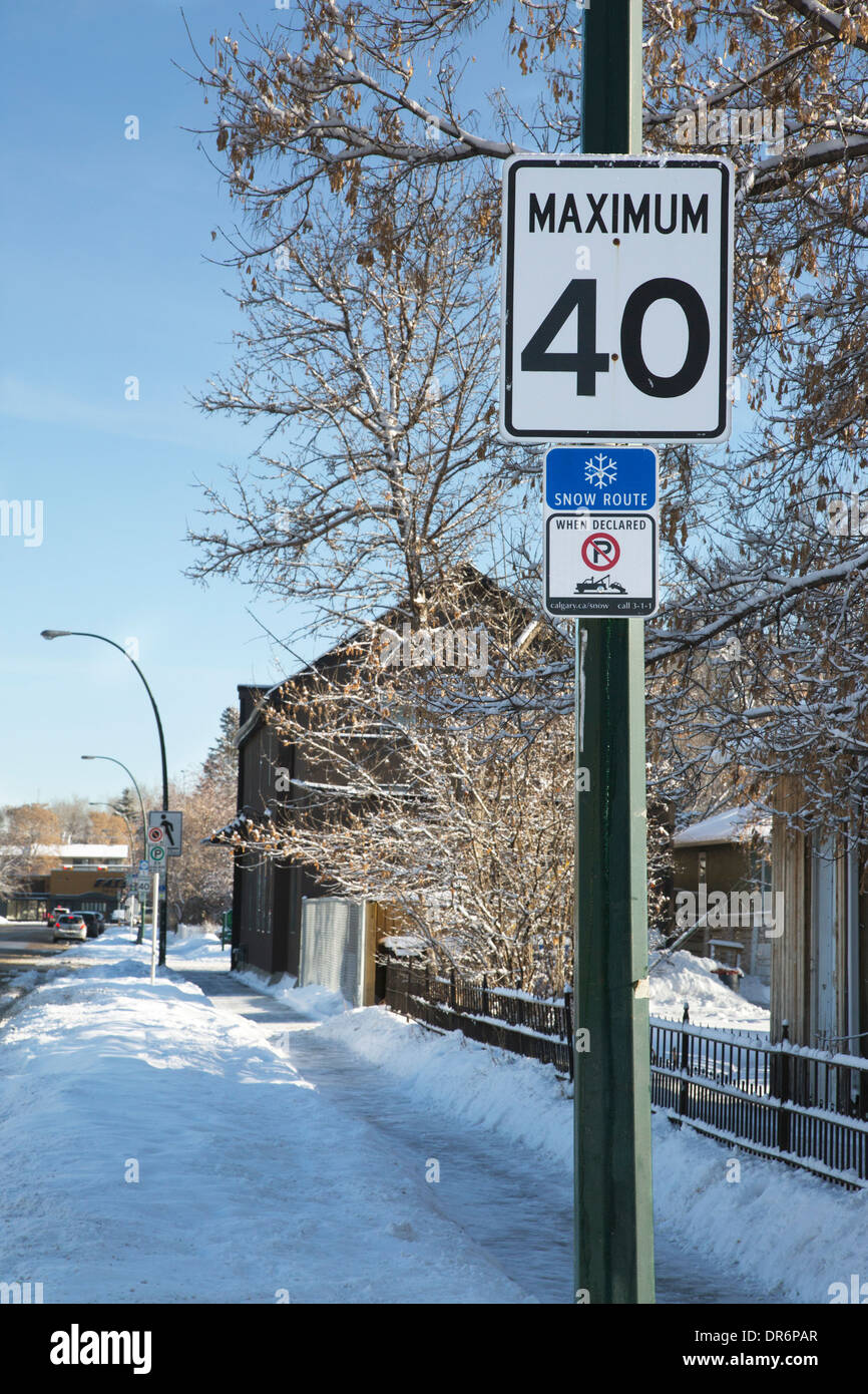 Segni di strada con limite di velocità di 40 km/h e n-parcheggio traino zona quando la strada è designato come un itinerario di neve. Foto Stock
