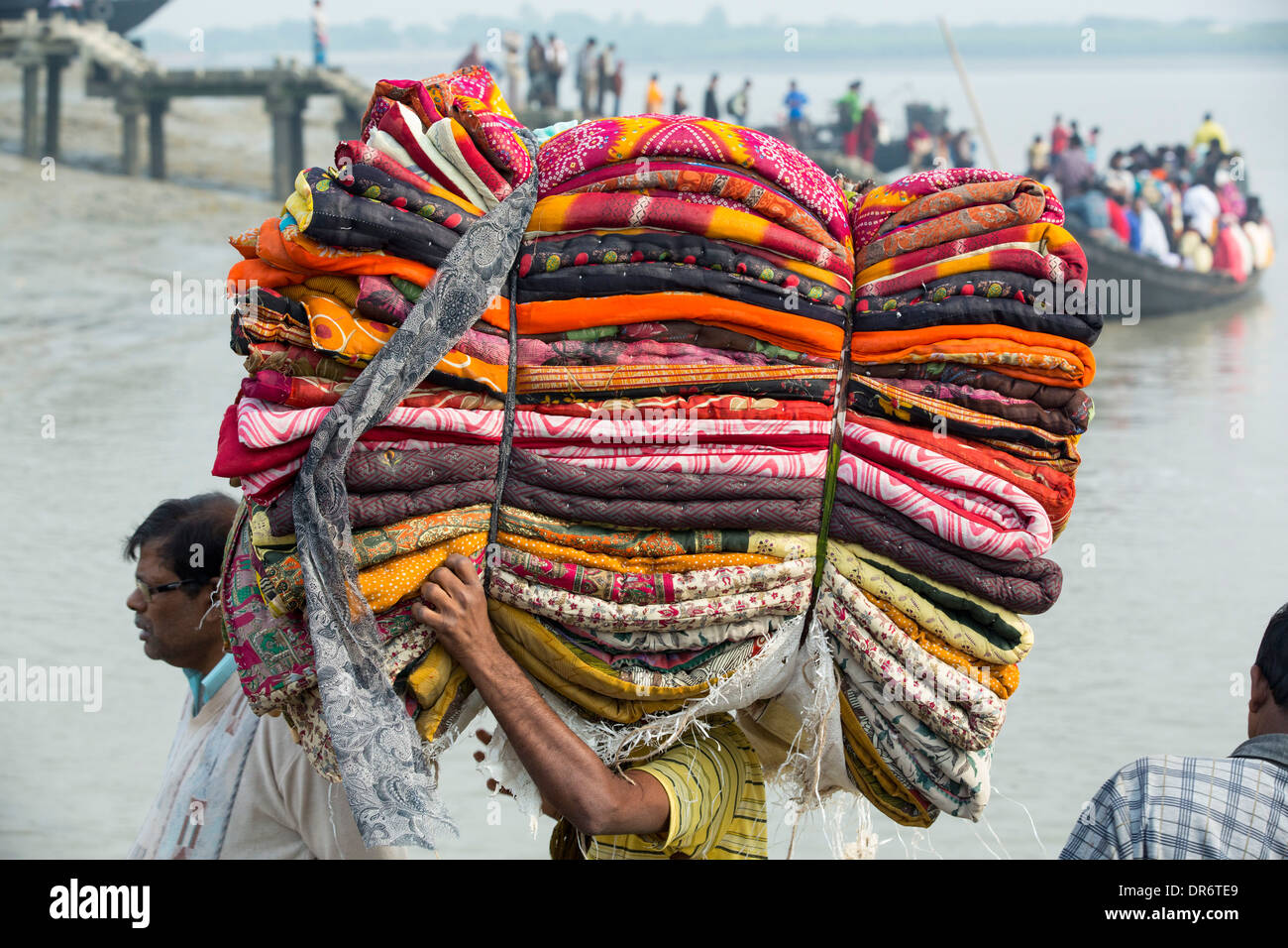 Un uomo che porta i tessuti in Sunderbans, un basso area del delta del Gange in India Orientale, che è molto vulnerabile a mare Foto Stock