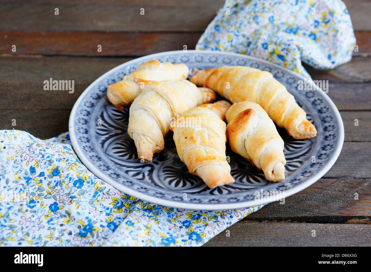 Dorate e croccanti croissant su una piastra, cibo closeup Foto Stock