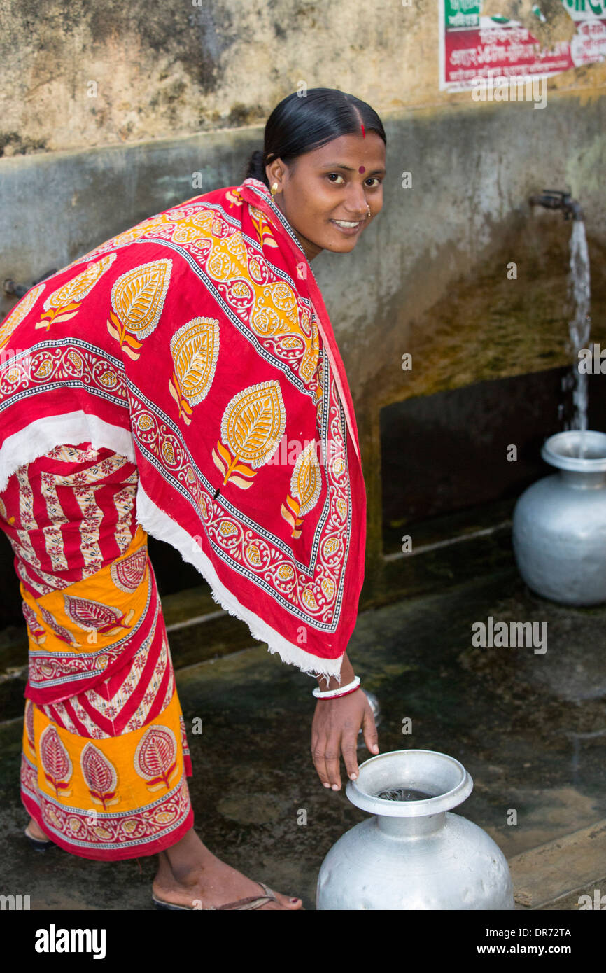 Gli abitanti di un villaggio in una remota isola nel Sunderbans, una bassa area sdraiato, vulnerabile di innalzamento del livello del mare, l'India, la raccolta di acqua da un pozzo di trivellazione e. Foto Stock