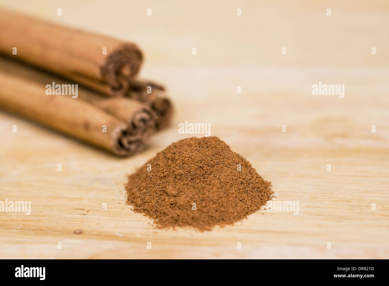 Bastoncini di cannella e la cannella in polvere su una tavola di legno. Foto Stock