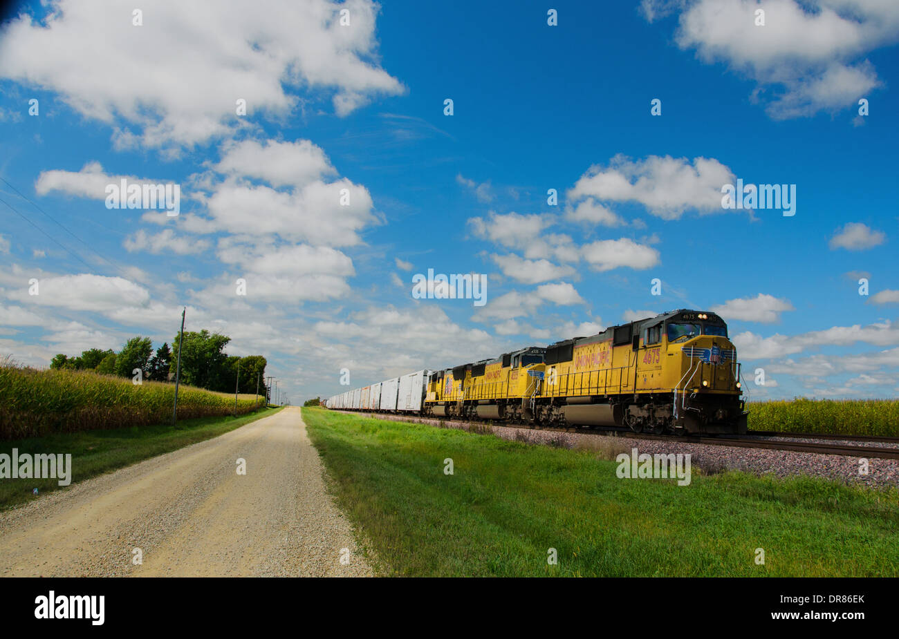 Lincoln Highway strada di ghiaia accanto ai binari della ferrovia dove la Union Pacific treno è in esecuzione nei pressi di Ashton, Illinois Foto Stock