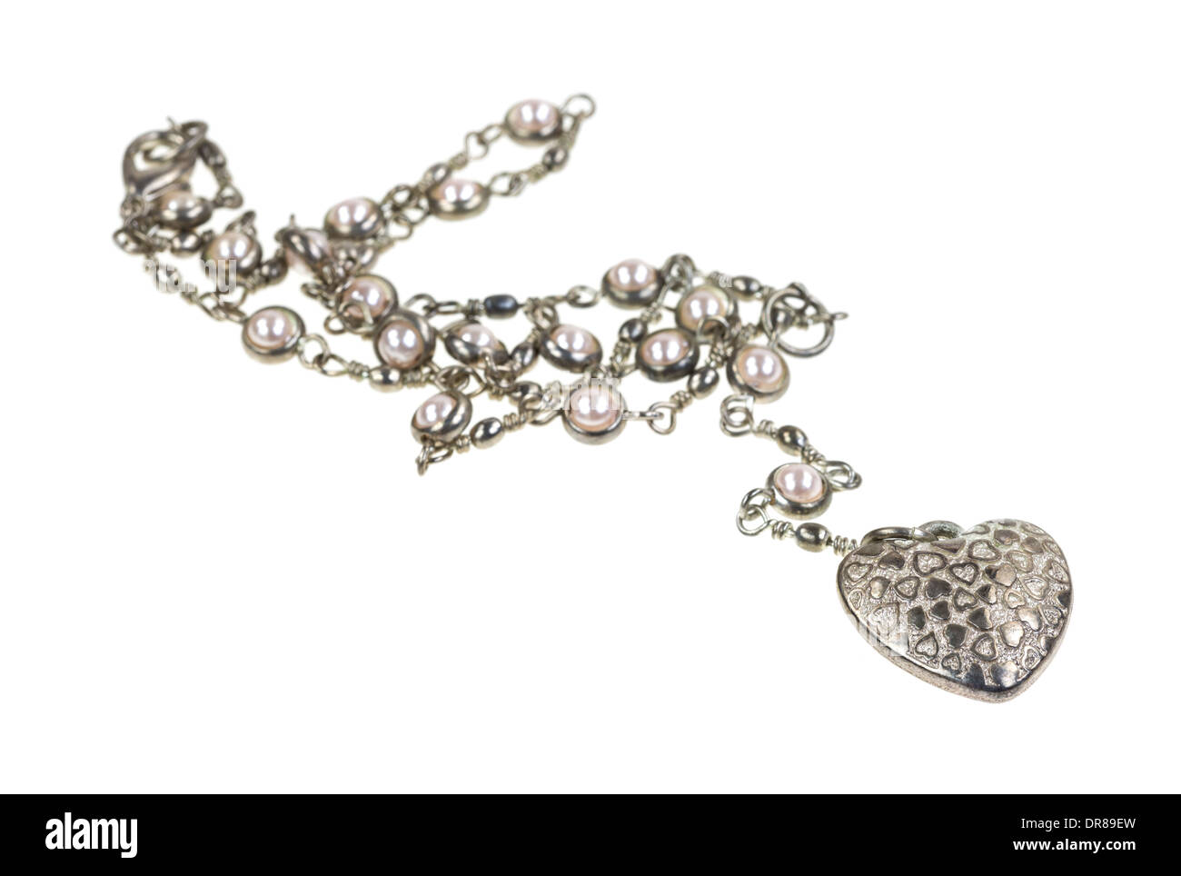 Un ciondolo a forma di cuore su una catena d'argento con falsi perle su uno sfondo bianco. Foto Stock