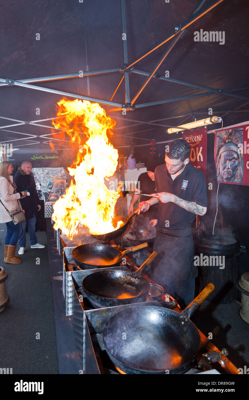 Brighouse Victorian Mercatino di Natale con supporto di stallo la vendita di cibo cotto nel wok con grandi fiamme,flambé Foto Stock