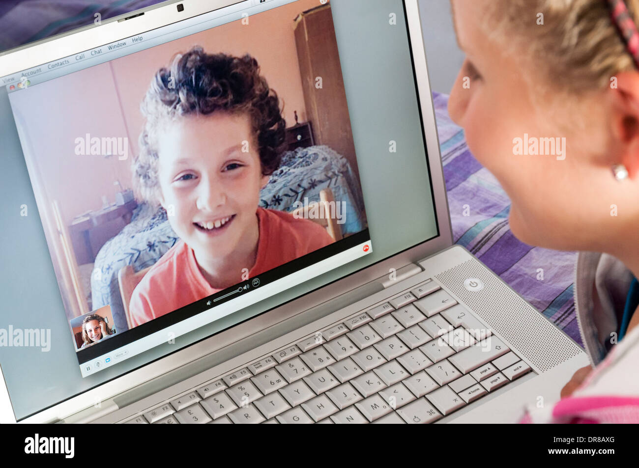 I bambini a parlare su Skype sul computer portatile Apple Computer, England, Regno Unito Foto Stock