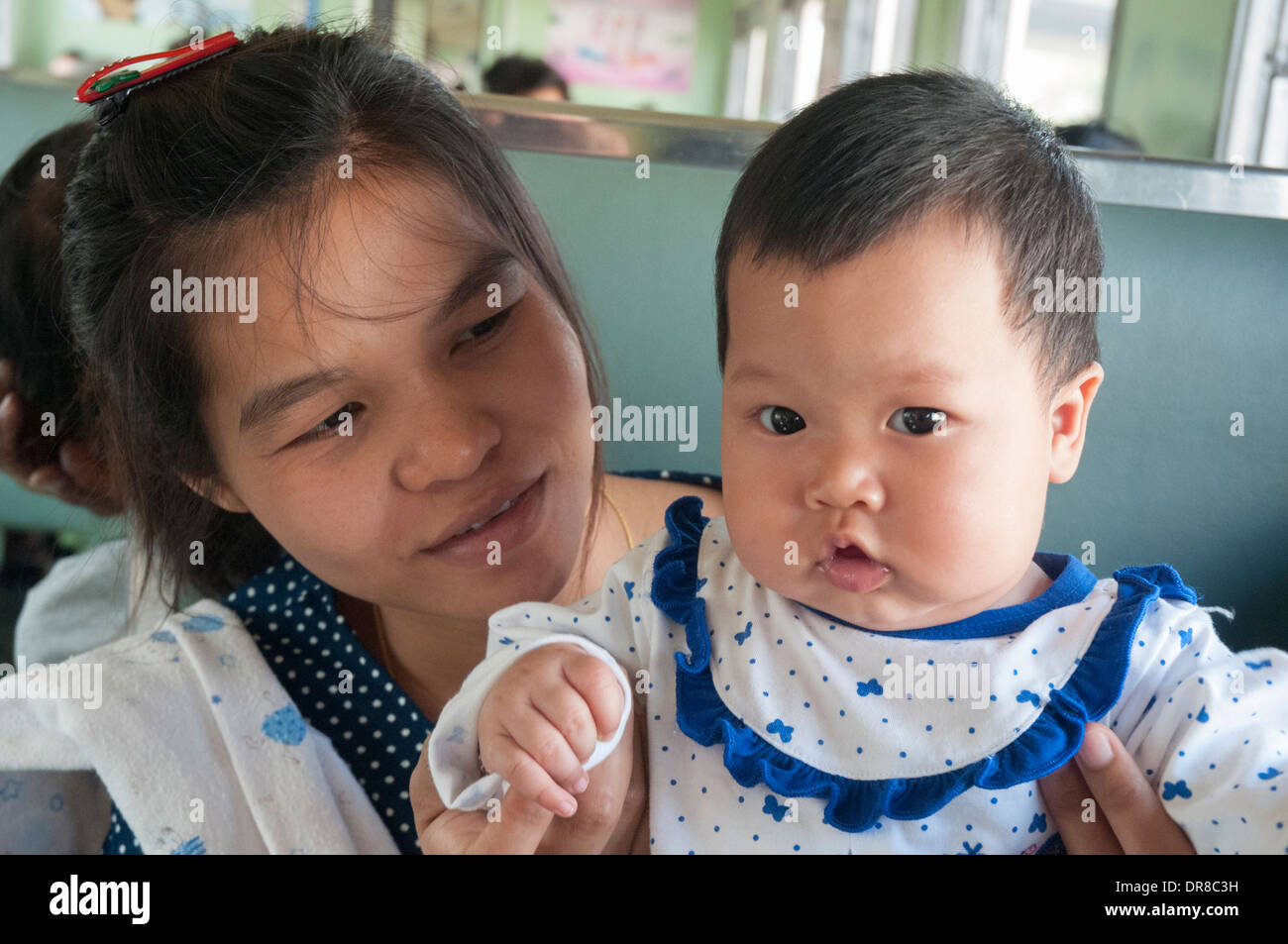 La madre e il bambino a bordo di una terza classe di treno locale da Bangkok a Ayutthaya, Thailandia Foto Stock