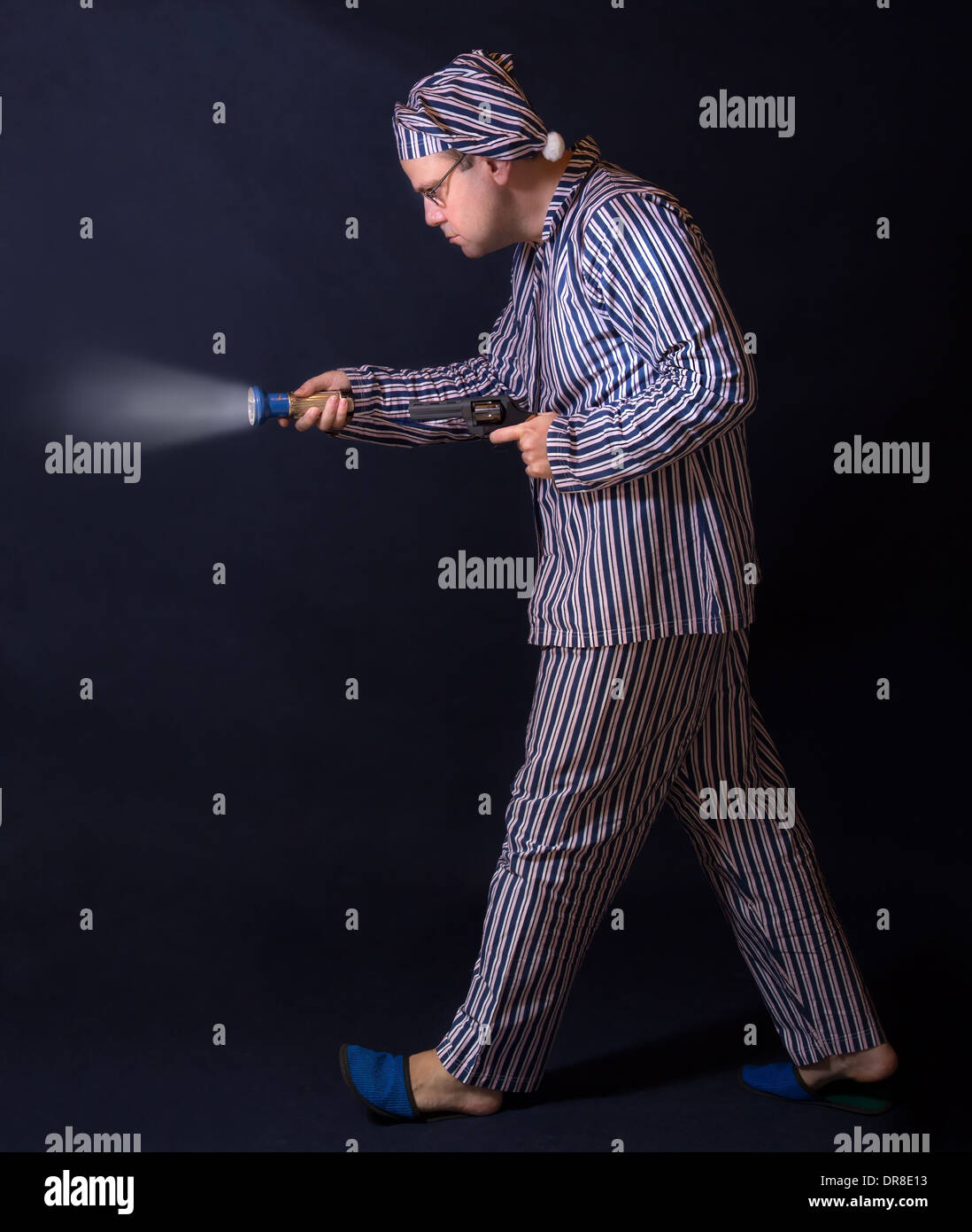 Uomo in pigiama in giro con una pistola Foto Stock