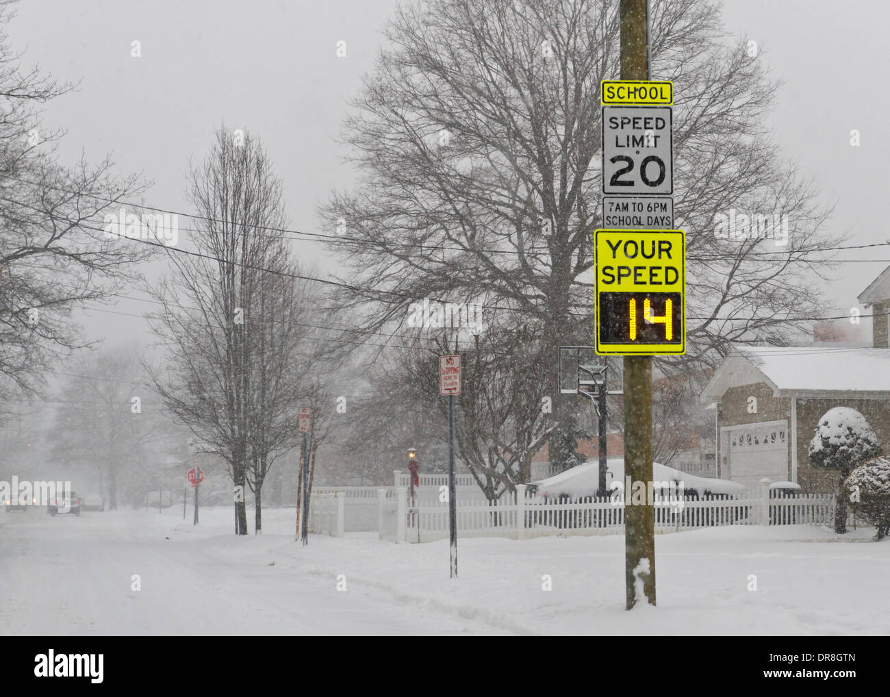 Merrick, New York, Stati Uniti Il 21 gennaio 2014. Un segno elettrico afferma che una vettura sta 14 mph, che è ben al di sotto del 20 miglia di limite di velocità, come la neve cade pesantemente sull'Isola lunga a causa della tempesta di neve, con fino a dieci centimetri di neve previsto. Il radar determina automaticamente la velocità delle vetture che sopraggiungono durante le ore scolastiche in questa zona della scuola. Credito: Ann e Parry/Alamy Live News Foto Stock