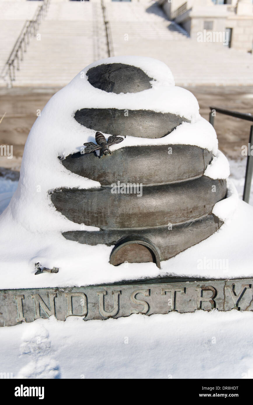 Statua di Utah simbolo dello stato, l'alveare, in rappresentanza dell'industria, di fronte al Capitol Building e coperto di neve. Foto Stock