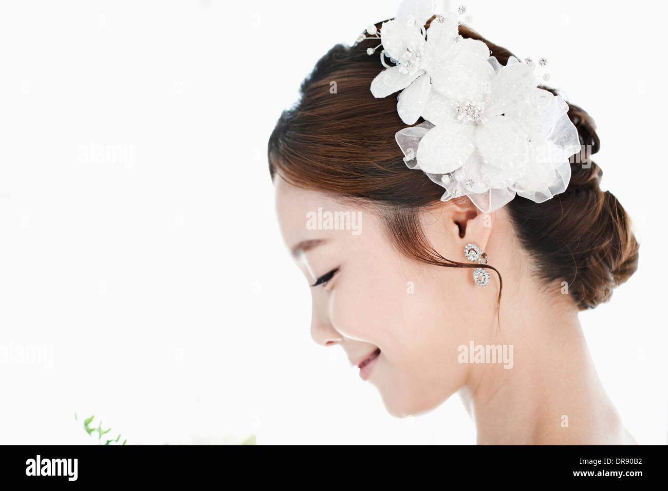 Immagine ravvicinata di una donna nel matrimonio capelli fiore di contenimento Foto Stock
