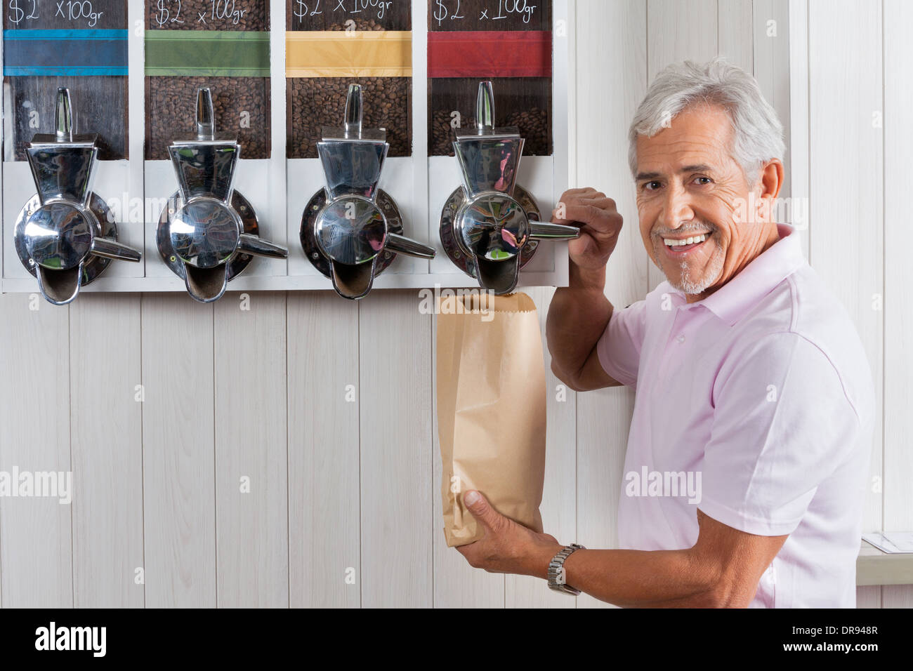Senior uomo Acquisto di chicchi di caffè dal distributore automatico Foto Stock