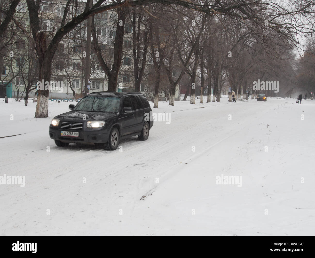 Lugansk, Ucraina - 22 Gennaio 2014: SUV guida su una coperta di neve su strada. Utilities Lugansk non affrontare con nevicata. Coperta di neve ghiacciata di marciapiedi e strade. Ciò è molto pericoloso per i pedoni e gli automobilisti che hanno viaggiato con cautela. Credito: Igor Golovnov/Alamy Live News Foto Stock