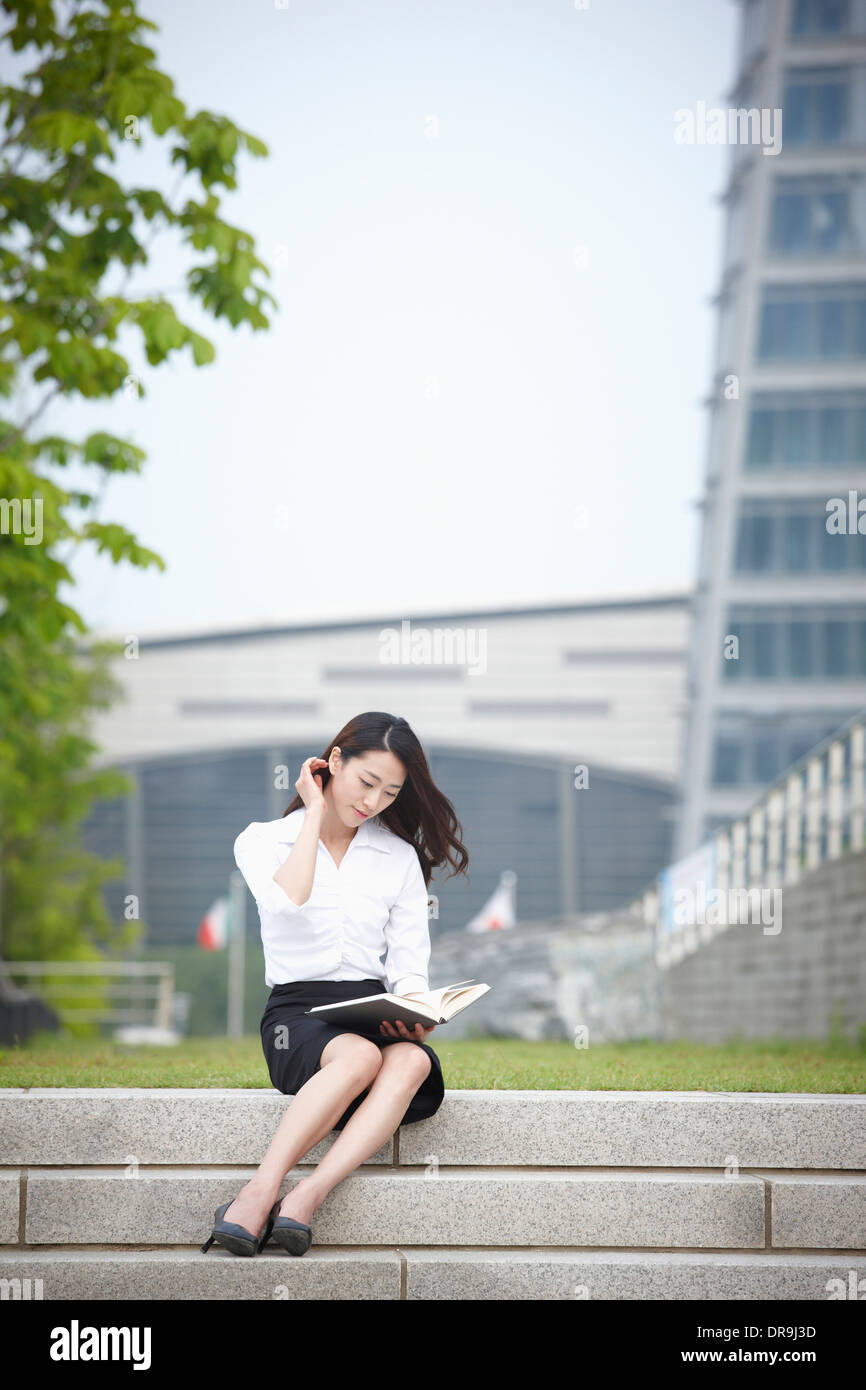 Un business donna seduta al di fuori e funzionante Foto Stock