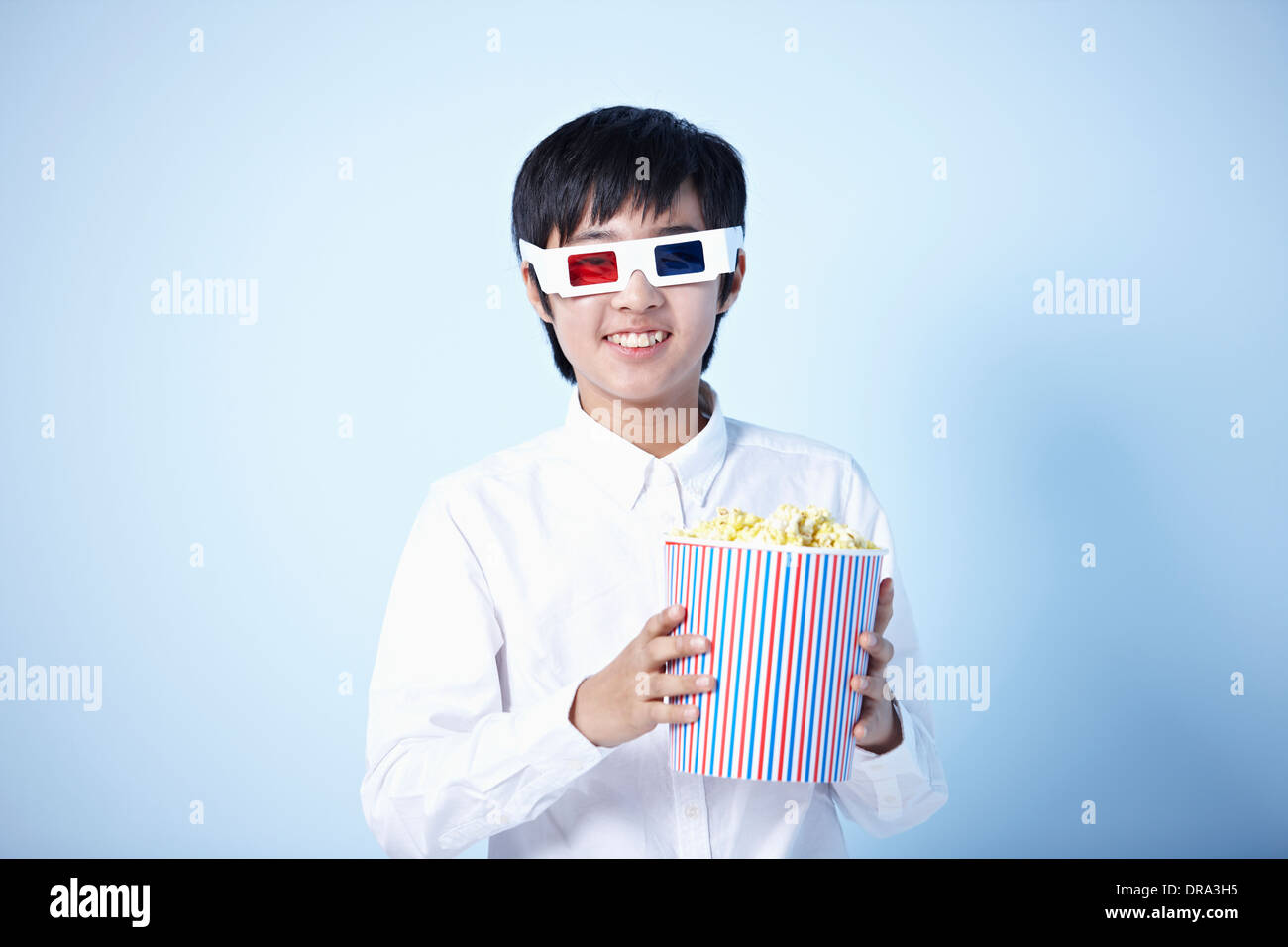 Un ragazzo a guardare un film in 3d con popcorn Foto Stock