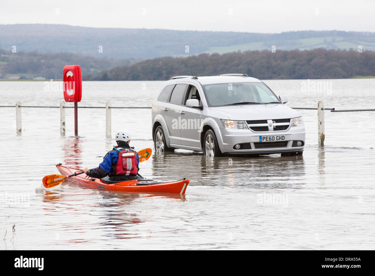 Kayakers nelle acque di esondazione su strada a Storth sul Kent Estuary in Cumbria, Regno Unito, durante il mese di gennaio 2014 tempeste Foto Stock