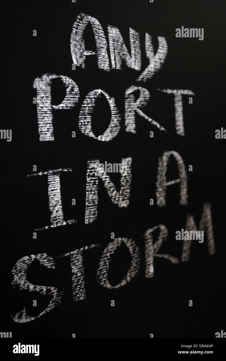 Chalk iscritto- Qualsiasi porta in una tempesta - parole scritte sulla lavagna. Foto Stock