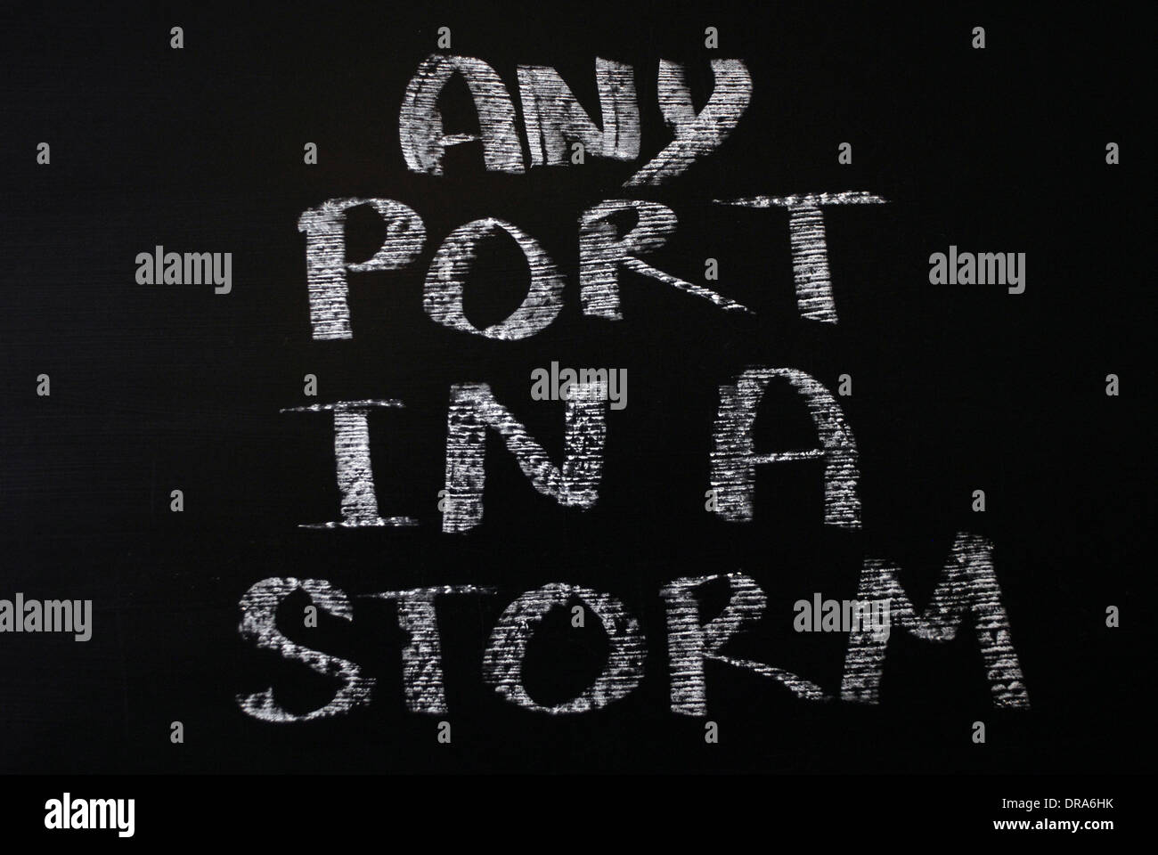 Chalk iscritto- Qualsiasi porta in una tempesta - parole scritte sulla lavagna. Foto Stock