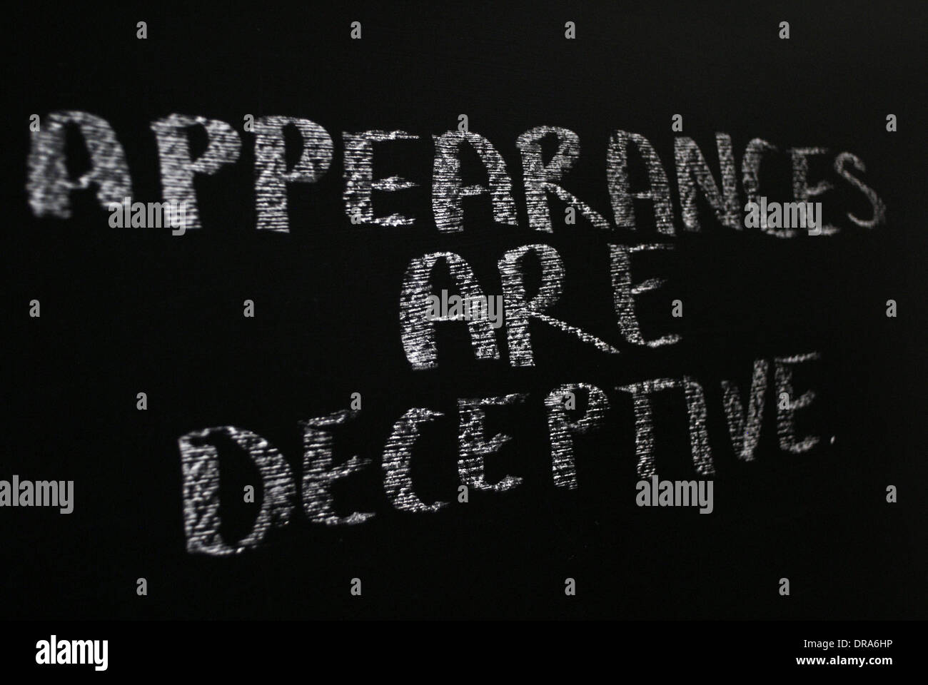 Chalk iscritto- Le apparenze sono ingannevoli - parole scritte sulla lavagna. Foto Stock