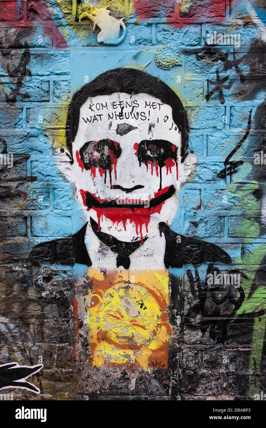 Scary Joker cerca uomo in un vestito con il volto insanguinato, graffiti su un edificio dalla facciata in mattoni in Olanda, Amsterdam, Paesi Bassi. Foto Stock