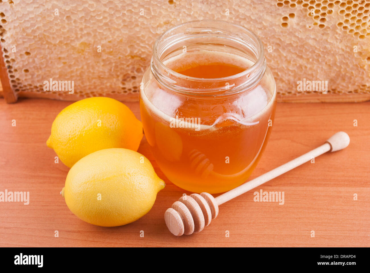 Miele di fresco in un barattolo di vetro e limoni. Foto Stock