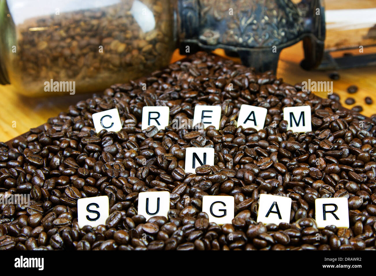 Panna zucchero N compitare usando piastrelle di gioco impostato nel caffè macinato con un antico macinino da caffè in background Foto Stock