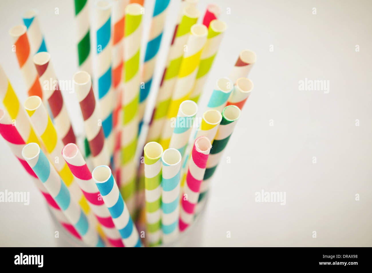 Striped drink cannucce di diversi colori in vetro su uno sfondo chiaro Foto Stock