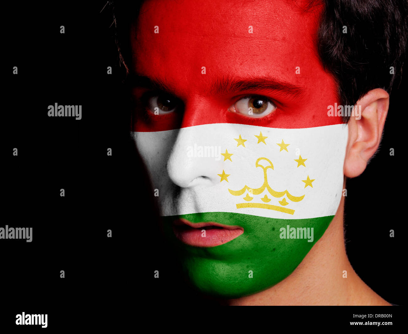 Bandiera del Tagikistan dipinta su una faccia di un giovane uomo Foto Stock