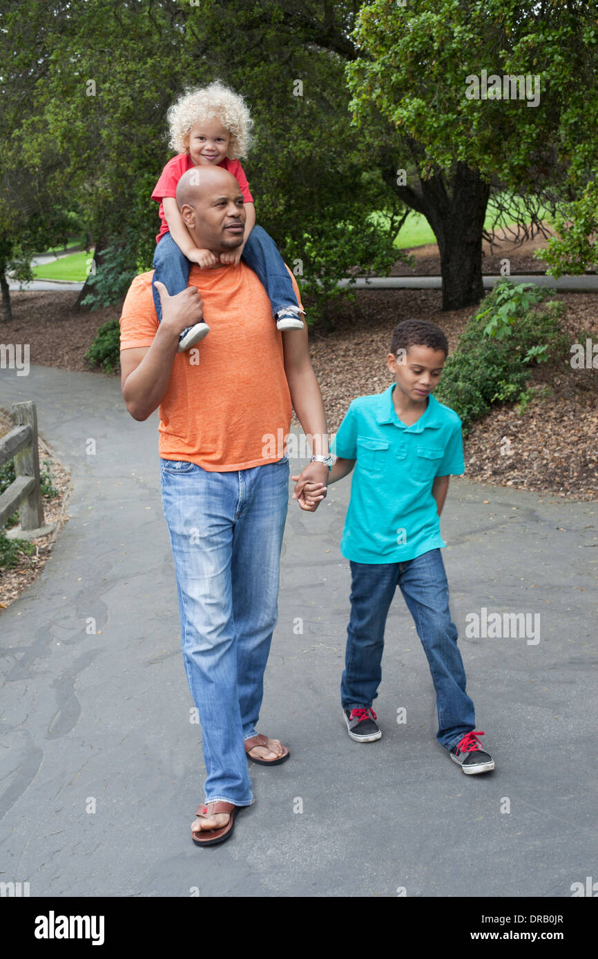 Padre con i bambini a piedi giù per un sentiero a Menlo Park Foto Stock
