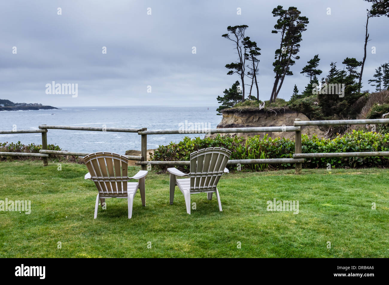 Due sedie a sdraio su un prato che si affacciano sull'oceano pacifico, grigio nuvoloso giorno. Depoe Bay, Oregon Foto Stock