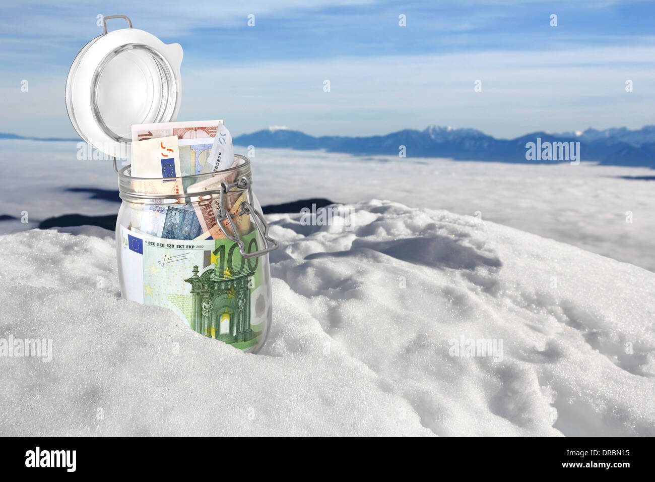 Le banconote in euro in vaso nella neve sulla cima della montagna Foto Stock