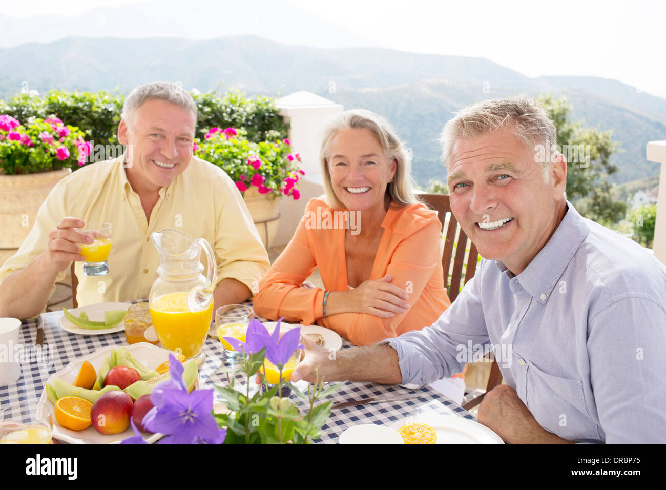 Senior amici gustando la prima colazione sul balcone Foto Stock