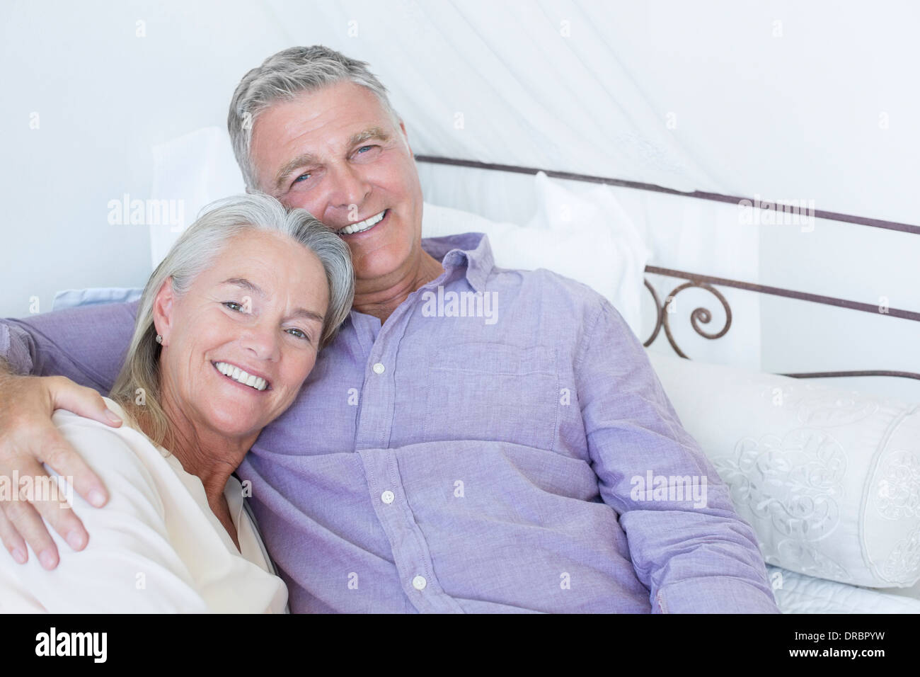 Coppia senior posa sul letto Foto Stock