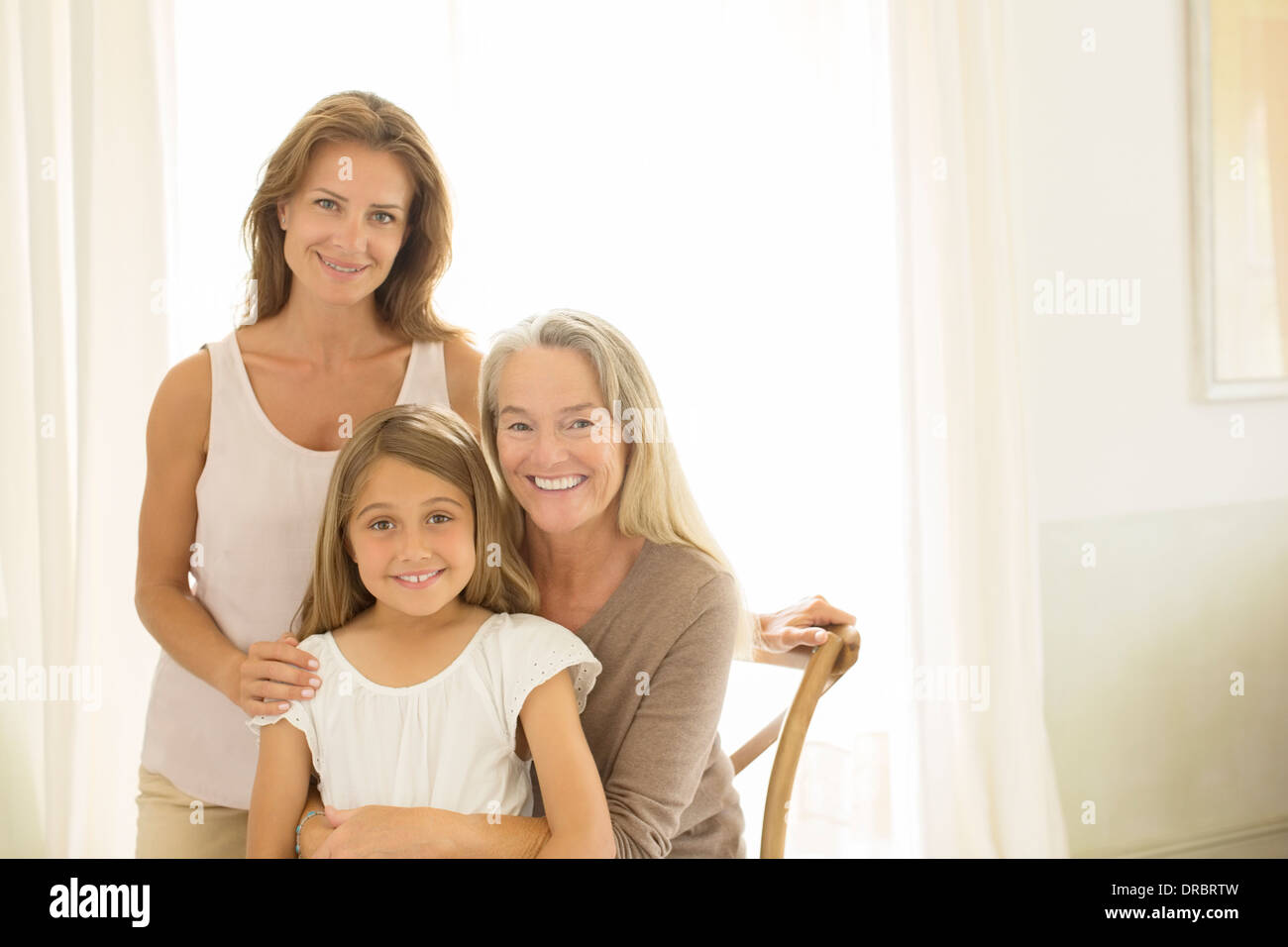 Multi-generazione donna sorridente in corrispondenza della finestra Foto Stock