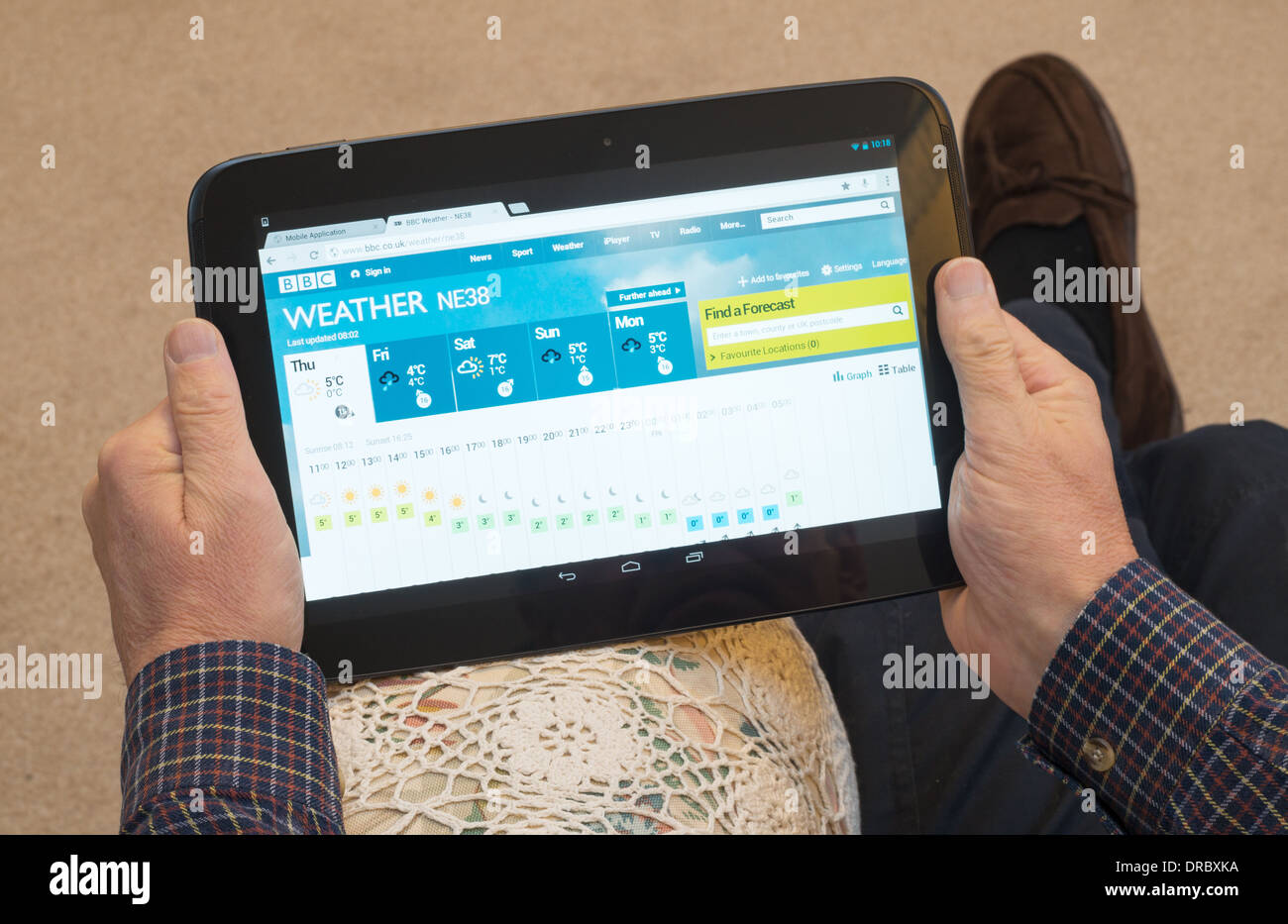 L'uomo reading UK previsioni meteo utilizzando Google Nexus 10 tablet Foto Stock