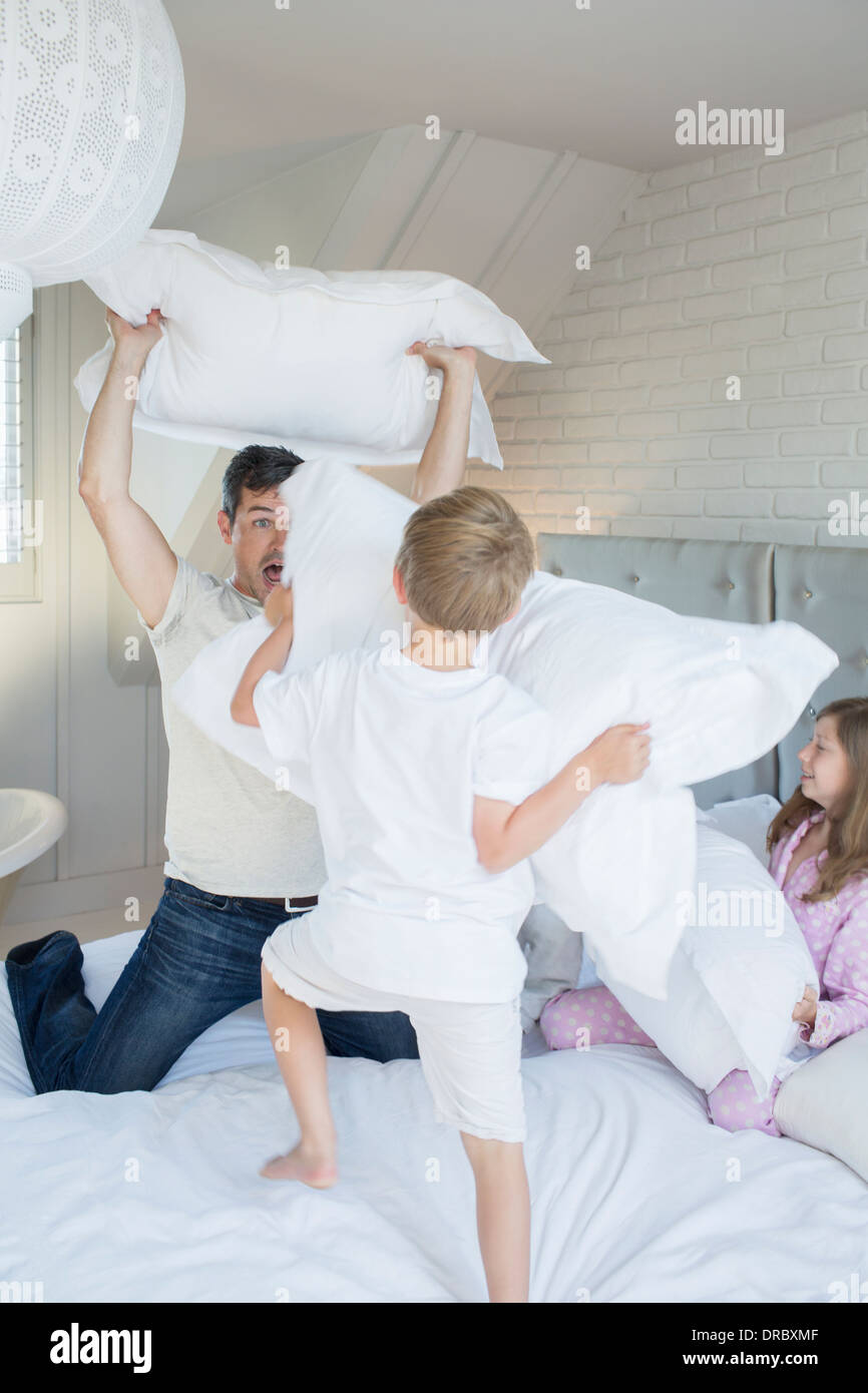 Padre e figli aventi pillow fight Foto Stock