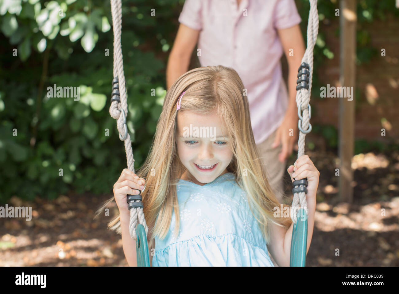 Padre figlia di spinta su swing Foto Stock