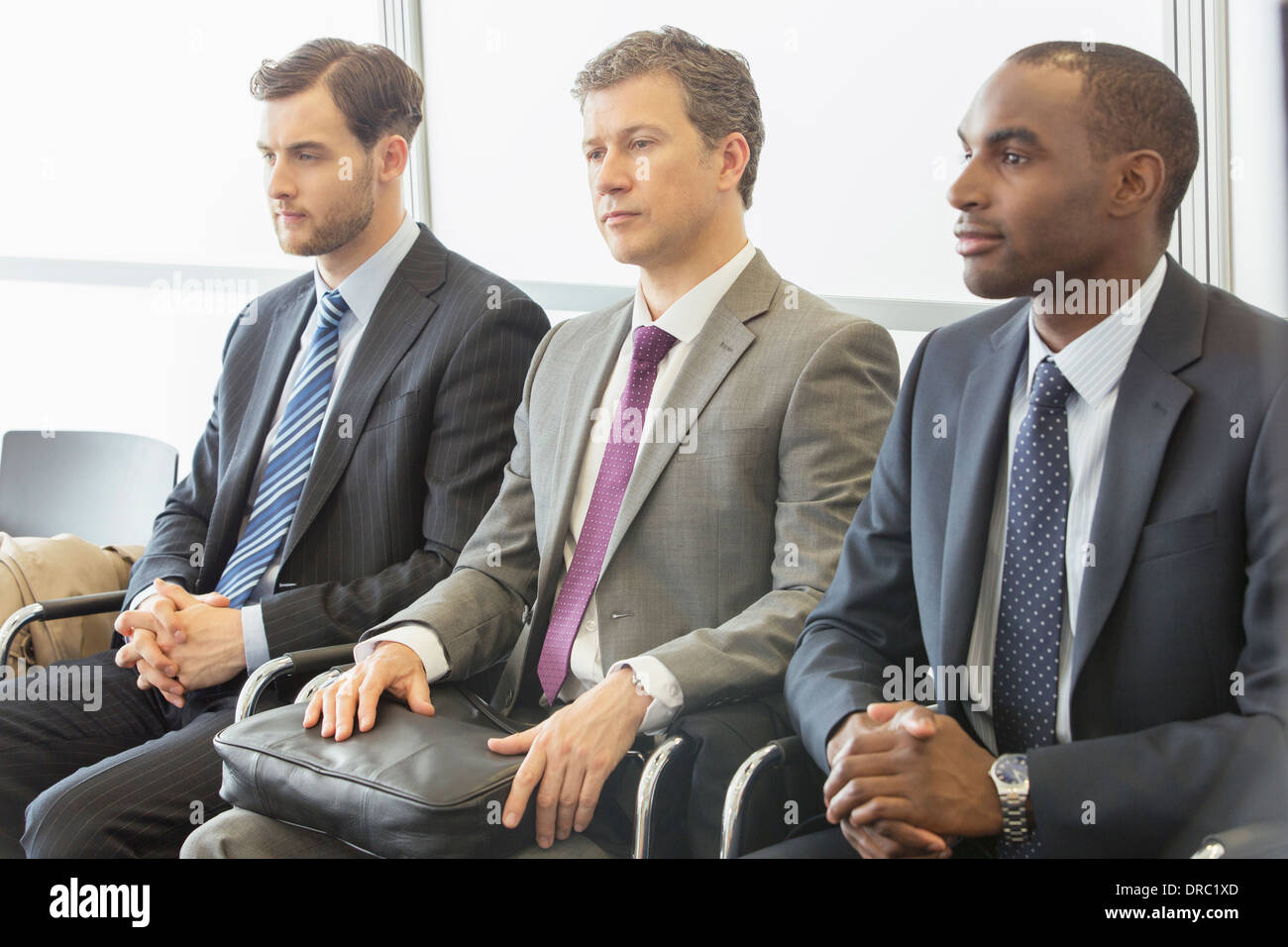 Uomini d'affari in seduta area di attesa Foto Stock